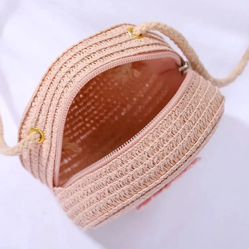 Sac rond en rotin rose clair avec bandoulière tressée, fermeture éclair et doublure imprimée, fait à la main.