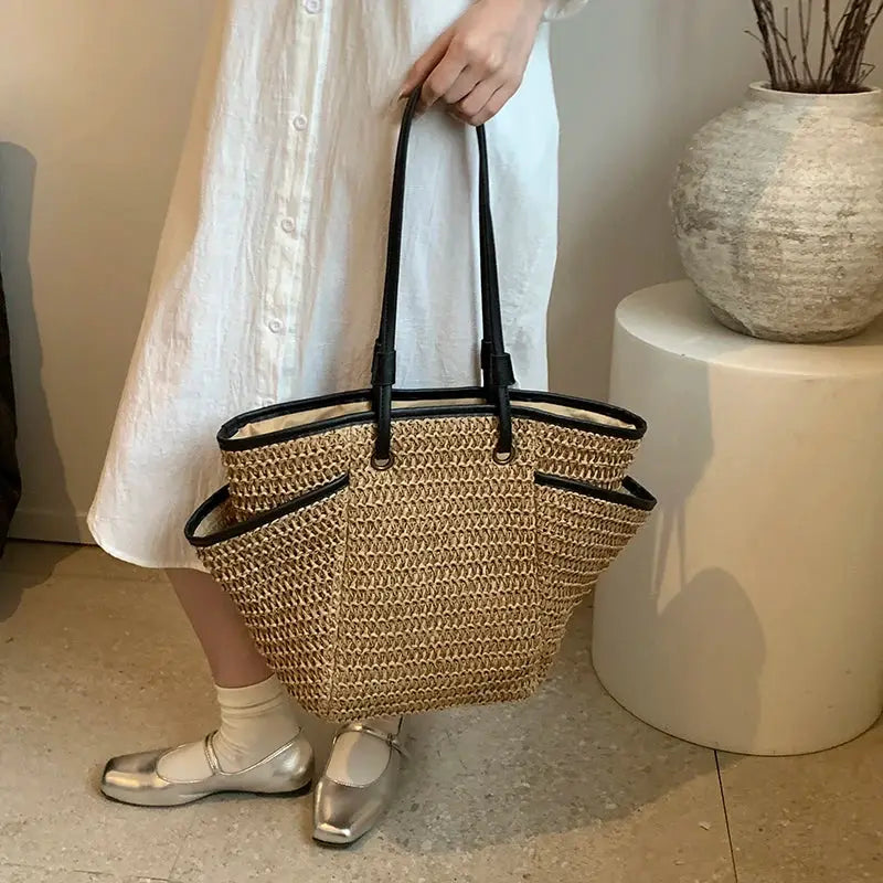 Sac fourre-tout en paille naturelle grande capacité avec poignées noires, style plage.