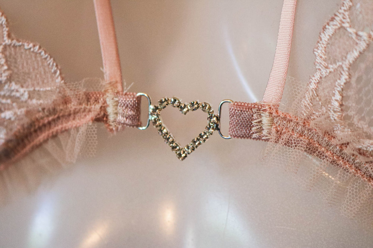 Détail du pendentif cœur en strass entre les bonnets du soutien-gorge Valkyrie